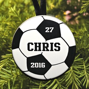 May include: A white and black soccer ball ornament with the number 27, the name "CHRIS", and the year 2016.
