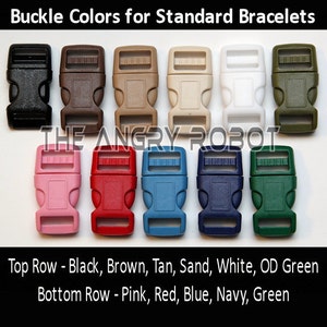 Puede incluir: Una variedad de hebillas de pl&aacute;stico en varios colores: negro, marr&oacute;n, beige, arena, blanco, verde oliva, rosa, rojo, azul, marino y verde. El texto "Buckle Colors for Standard Bracelets" est&aacute; en la parte superior.