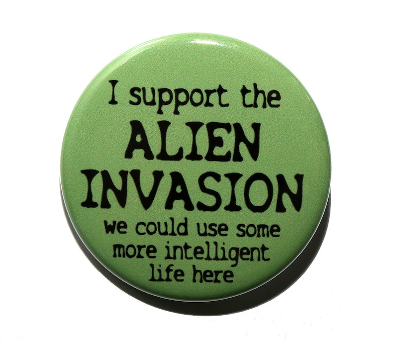 May include: Green button with the text "I support the ALIEN INVASION we could use some more intelligent life here" in black.