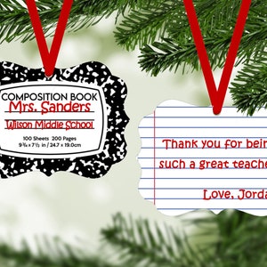 May include: Two Christmas ornaments shaped like composition notebooks. The first ornament is black and white with the text "COMPOSITION BOOK Mrs. Sanders Wilson Middle School 100 Sheets 200 Pages 9 3/4 x 7 1/2 in / 24.7 x 19.0 cm". The second ornament is white with blue lines and the text "Thank you for being such a great teacher! Love, Jordan".