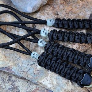 May include: Four black paracord keychains with glow-in-the-dark skull beads and black tips.