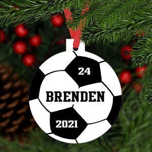 May include: A white and black soccer ball Christmas ornament with the number 24, the name "BRENDEN", and the year 2021 printed on it.