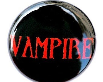 May include: A black button with the word "Vampire" in red letters.