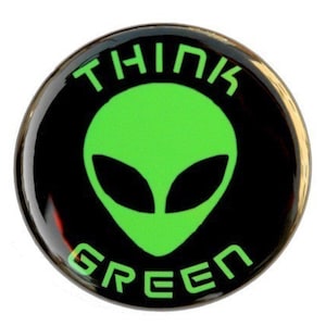 May include: A black and green round button with a green alien face and the text "Think Green" in white.