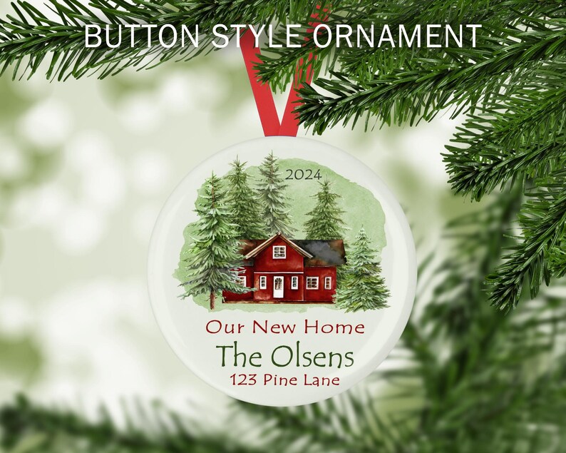 May include: A white round Christmas ornament with a watercolor illustration of a red house with green trees and the text "2024 Our New Home The Olsens 123 Pine Lane"