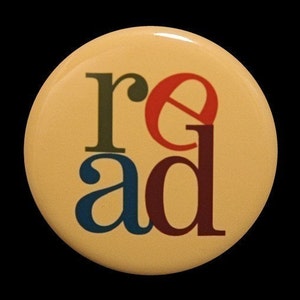 May include: A yellow button with the word "read" in colorful letters. The letters are in different colors and styles. The "r" is green, the "e" is red, the "a" is blue, and the "d" is maroon.