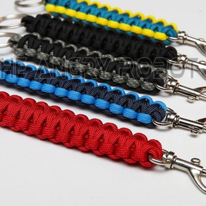 May include: Five colorful paracord keychains with silver key rings and swivel clips. The keychains are red, blue, black, gray, and yellow.