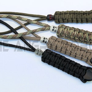 May include: Four paracord keychains with skull beads and black plastic tips. The keychains are in green, camouflage, tan, and black.
