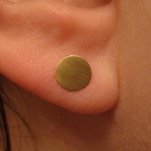 May include: A gold-colored round earring stud.