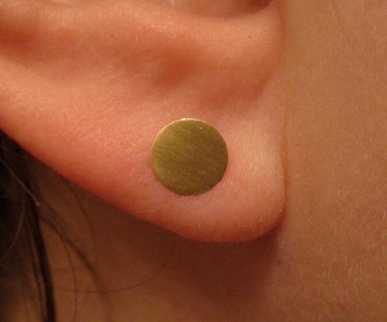 May include: A gold-colored round earring stud.