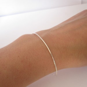Thin Dainty 1.3mm Cuff Bracelet with Hammered Ends matte solid 0.925 sterling silver 0178 on the wrist Virginia Wynne Designs VWD