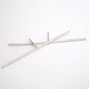May include: A pair of silver earrings with a simple, minimalist design. Each earring features two thin, straight bars that intersect at a single point.