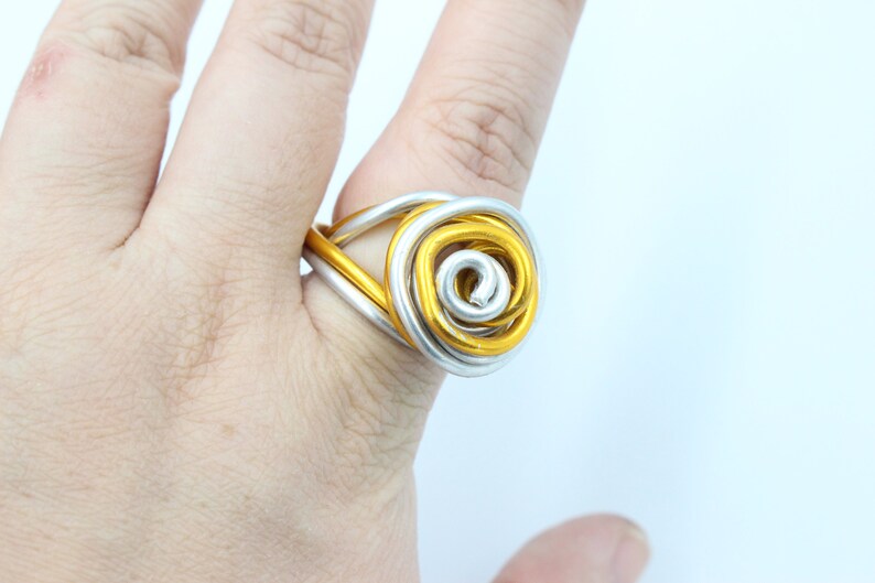 May include: A gold and silver wire ring with a rose design.