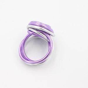 May include: A silver and purple wire ring with a twisted design.