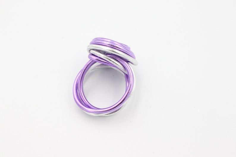 May include: A silver and purple wire ring with a twisted design.