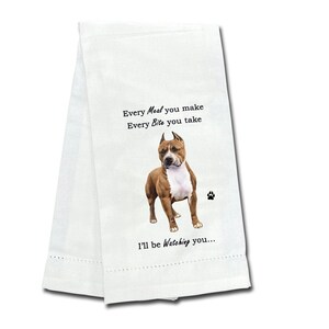 May include: White kitchen towel with a brown and white American Staffordshire Terrier dog printed on it. The text reads "Every Meal you make Every Bite you take I'll be Watching you..."