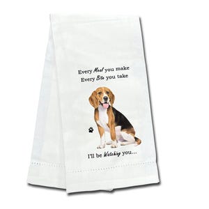 May include: White kitchen towel featuring a Beagle dog illustration. The towel has the text "Every Meal you make, Every Bite you take, I'll be watching you..." printed on it. The Beagle is brown, black, and white.