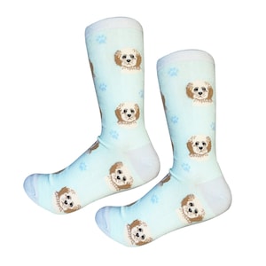 Op de afbeelding: Een paar lichtblauwe sokken met een patroon van bruine honden en blauwe voetafdrukken.