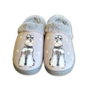 May include: A pair of gray and white fuzzy slippers with a miniature schnauzer dog design. The slippers have a gray fur lining and a gray sole.