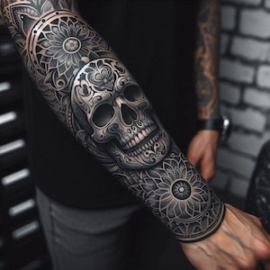 May include: Detailed black and gray tattoo design featuring a skull with intricate floral and ornamental patterns. The tattoo covers the forearm and upper arm, showcasing a blend of dark and light shading for depth.