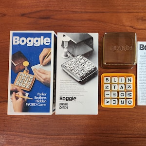 Pode incluir: Um jogo de tabuleiro vintage Boggle com uma grade amarela de peças de letras, uma caixa marrom com a palavra "Boggle" nela, uma caixa branca com instruções e um relógio de areia. O jogo foi projetado para ajudar os jogadores a encontrar palavras rolando as peças de letras.