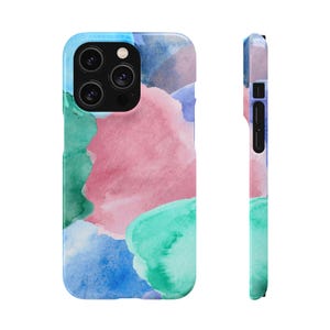 Peut inclure: Coque de téléphone colorée avec un motif aquarelle. Le design présente des éclaboussures roses, vertes et bleues sur un fond bleu. Le côté de la coque est également visible, avec le même motif.