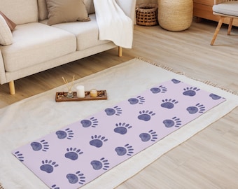May include: A lavender yoga mat with a repeating pattern of dark purple paw prints.