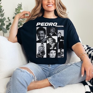 Pode incluir: Uma camiseta preta com uma colagem de fotos em preto e branco de Pedro Pascal. O texto "PEDRO PASCAL" é impresso em branco na camiseta.