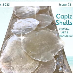 May include: A magazine cover with the title "Crafting with Nature" and the text "July 2023, Issue 25." The cover features Capiz shells on a decorative tray. Additional text includes "Coastal Art & Handicrafts" and crafting supply topics.