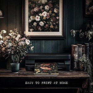 May include: A black and silver printer with a floral print being printed. The printer is on a dark wood table with a vase of flowers and books on the table. The text "EASY TO PRINT AT HOME" is on the table.