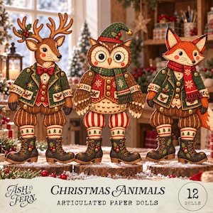 May include: Three articulated paper dolls featuring a deer, an owl, and a fox dressed in winter clothing. Each figure wears a green jacket, red vest, and boots with holly accents. The text reads: Ash & Fern Christmas Animals Articulated Paper Dolls 12 Dolls.