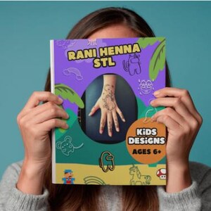 Könnte beinhalten: Ein Buch mit dem Titel "Rani Henna STL" mit einem lila Einband mit einem Henna-Hand-Design. Das Buch trägt die Worte "Kids Designs Ages 6+" auf einem kreisförmigen orangefarbenen Etikett. Der Hintergrund ist türkis.