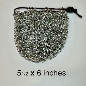 Peut inclure: Une pochette en cotte de mailles argentée, d'environ 14 x 15 cm, avec une fermeture à cordon noire. La pochette est faite de petits anneaux métalliques imbriqués, créant une surface flexible et texturée. Le texte sur l'image indique "5 1/2 x 6 inches".