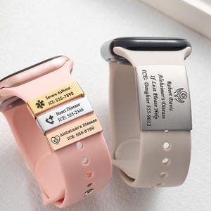 May include: Two silicone watch bands with medical alert tags. The pink band features three small metal tags engraved with Severe Asthma, Heart Disease, and Alzheimer's Disease. The beige band has a large silver tag engraved with Robert Davis, Alzheimer's Disease, If Lost Please Help, and ICE: Daughter 555-9012.