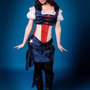 May include: A woman wearing a blue and red corset with a white star on the skirt. The corset has a red, white, and blue design and is accented with gold buckles. She is wearing black boots and has red hair.