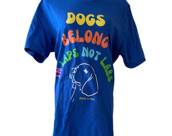 May include: Blue t-shirt featuring a white dog illustration and the text "Dogs Belong In Laps Not Labs". The text is in rainbow colours.