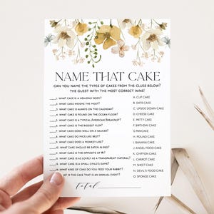 Könnte beinhalten: Eine druckbare Spielkarte mit einem floralen Design und dem Titel "Name That Cake". Die Karte enthält eine Liste von 15 Kuchenarten und Hinweise, die den Spielern helfen, den richtigen Kuchen zu erraten.