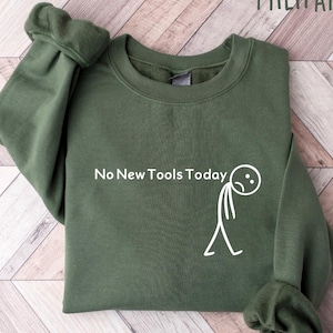 May include: Military green sweatshirt with the text "No New Tools Today" and a stick figure with a sad face. The sweatshirt is made of a soft material and has a crew neck.
