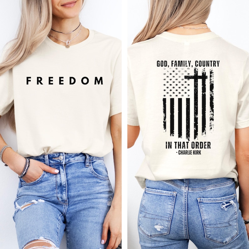 Peut inclure: T-shirt cr&egrave;me avec le mot "FREEDOM" en lettres noires grasses sur le devant. Le dos du t-shirt pr&eacute;sente un motif de drapeau am&eacute;ricain vieilli avec une croix et le texte "GOD, FAMILY, COUNTRY IN THAT ORDER - CHARLIE KIRK."