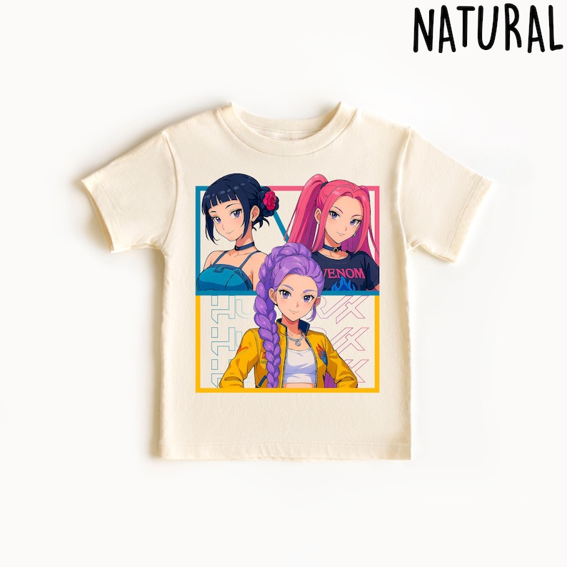 May include: Cream-colored t-shirt featuring a colorful anime-style graphic of three girls. The graphic is divided into sections with the word "VENOM" visible. The word "NATURAL" is printed at the top right of the shirt.