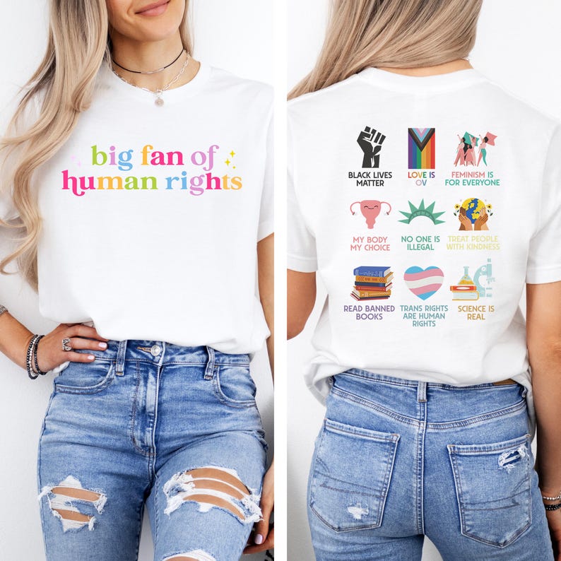 May include: White t-shirt with the text "big fan of human rights" in rainbow colours on the front. The back of the shirt features various graphic icons and phrases, including "Black Lives Matter" and "Feminism is for Everyone".