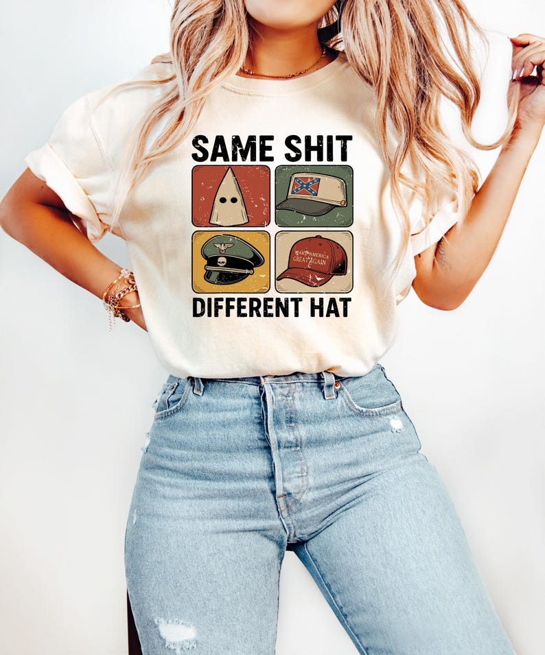 Pu&ograve; includere: T-shirt color crema con la scritta nera "SAME SHIT DIFFERENT HAT". Il design presenta quattro quadrati con immagini di diversi cappelli, tra cui un cappuccio del KKK e un cappello "Make America Great Again".