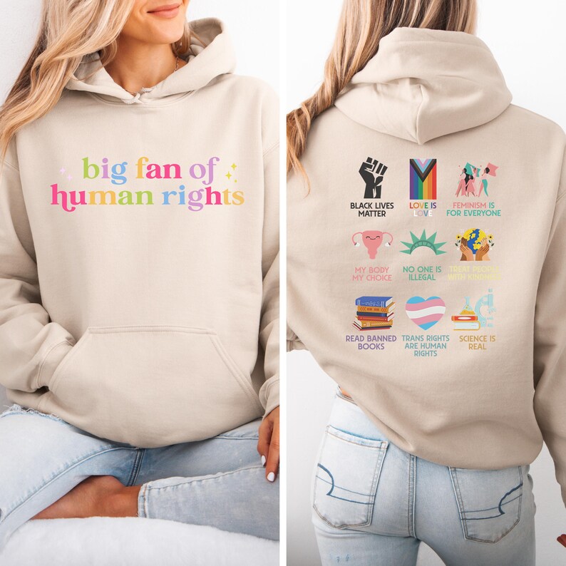May include: A beige hoodie with a front pocket and a hood. The front of the hoodie has the text "big fan of human rights" in colourful letters. The back of the hoodie has various graphics and text including "Black Lives Matter" and "Love is Love".