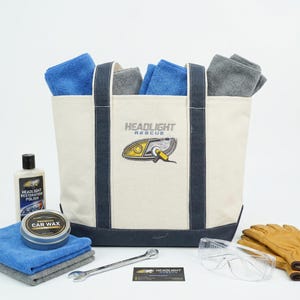 Custom logo canvas tote bag with headlight repair branding, filled with car care products, microfiber towels and tools, promotional business gift bag