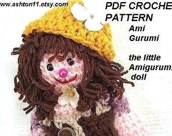 May include: PDF crochet pattern for a little amigurumi doll. The doll is wearing a yellow hat with a white flower and a pink dress. The doll has brown hair and a pink nose.