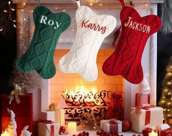 May include: Three personalized dog bone-shaped Christmas stockings hanging on a fireplace mantel. The stockings are green, white, and red with the names "Roy", "Karry", and "Jackson" embroidered on them.