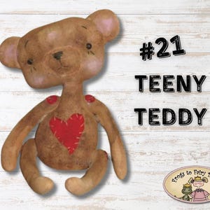 Puede incluir: Un oso de peluche marrón, hecho a mano, de estilo primitivo con un corazón rojo en el pecho. El oso está sentado sobre un fondo de madera blanca. El texto "#21 TEENY TEDDY" está en negro sobre el oso.