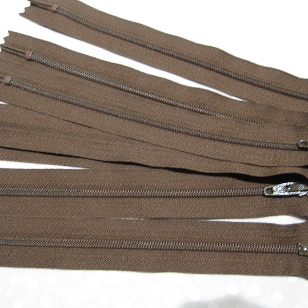 Seven medium brown zippers that are 7" long