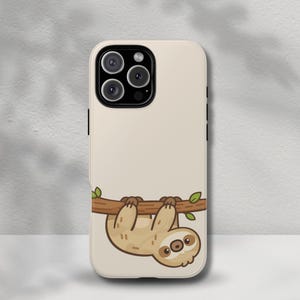 May include: A beige phone case featuring a cartoon sloth hanging from a brown branch with green leaves. The sloth is light brown with a cream-colored face and large, round eyes. The phone case has a glossy finish.