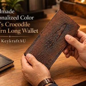 May include: A long rectangular wallet with a brown crocodile skin texture pattern. The text on the image reads: Handmade Personalized Color Men's Crocodile Pattern Long Wallet by KeykraftAU. The wallet features a raised, embossed crocodile design.